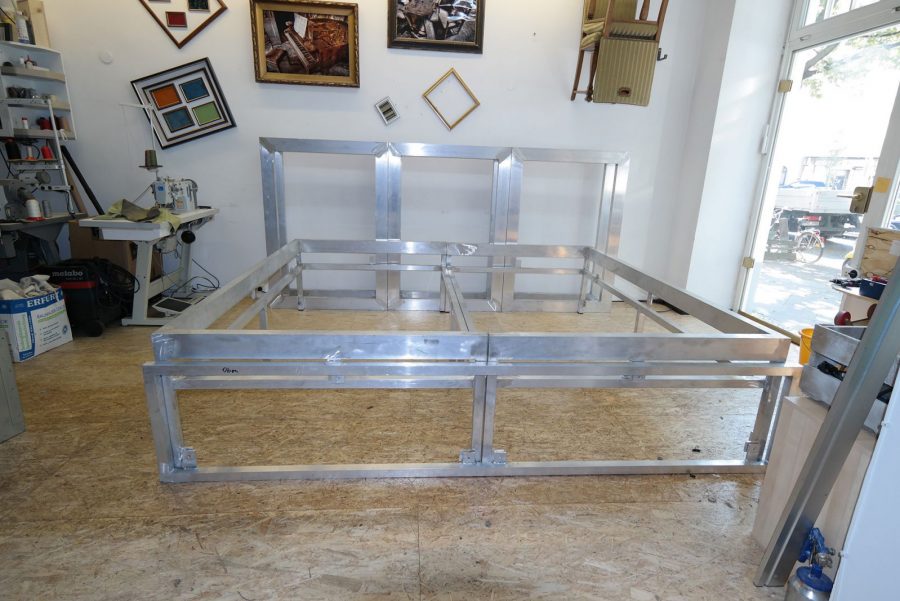 Metallbett, rot bezogen mit Rautenheftung