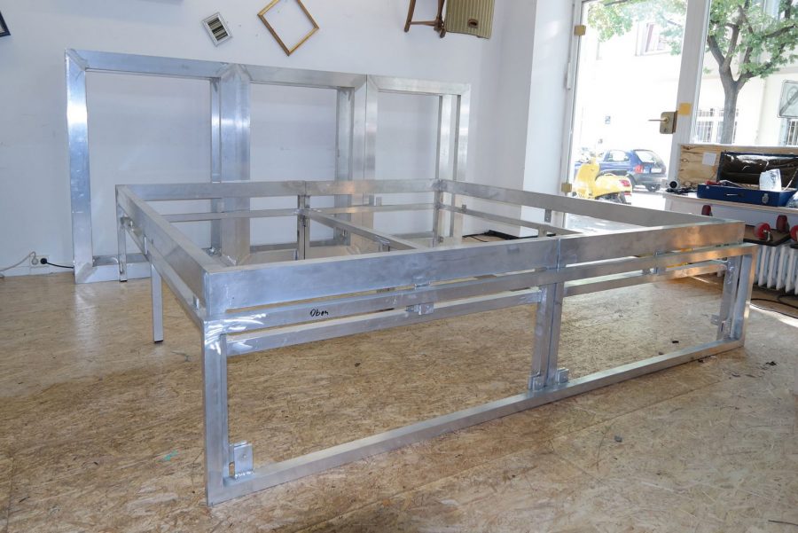 Metallbett, rot bezogen mit Rautenheftung