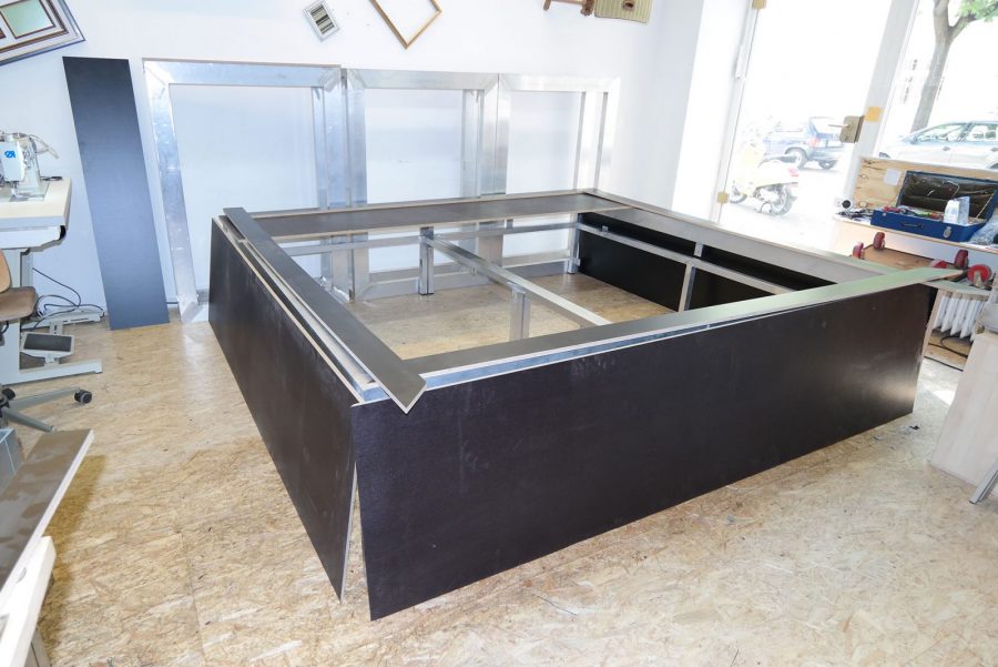 Metallbett, rot bezogen mit Rautenheftung