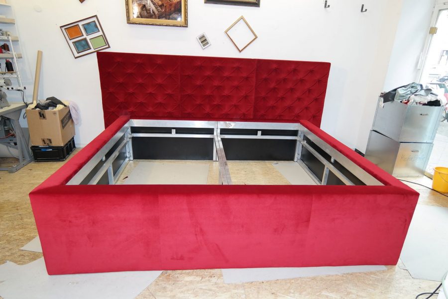 Metallbett, rot bezogen mit Rautenheftung